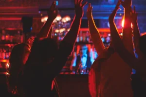 Restaurant guests raising their hands and enjoying an energetic live music experience