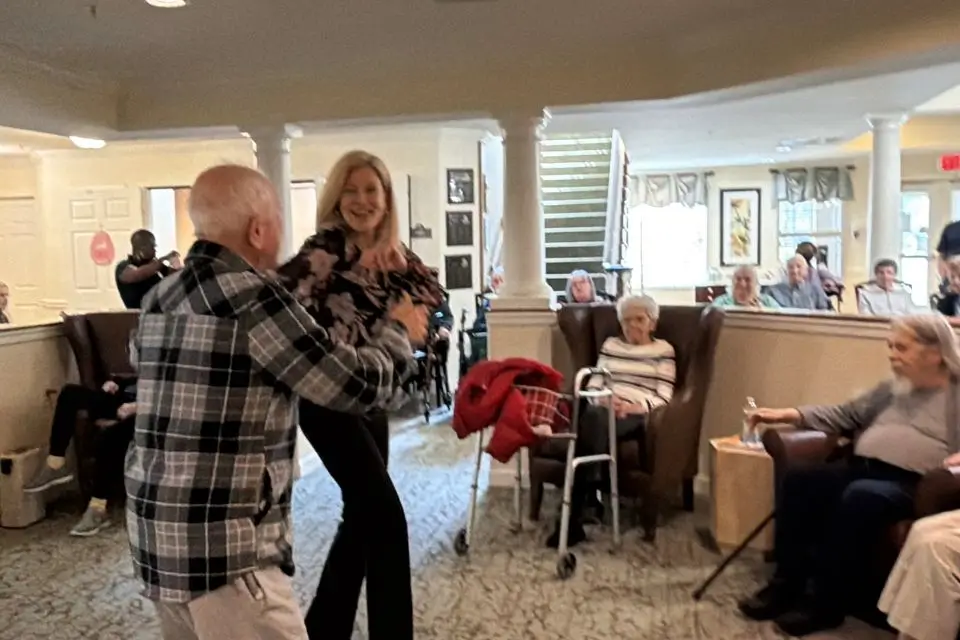 Female singer dancing with a resident during an assisted living entertainment program