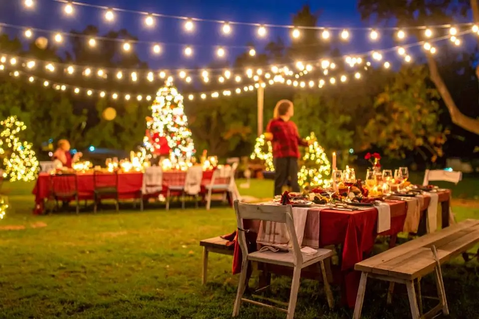 Holiday outdoor party in NJ with string lights and decorated tables for an evening celebration