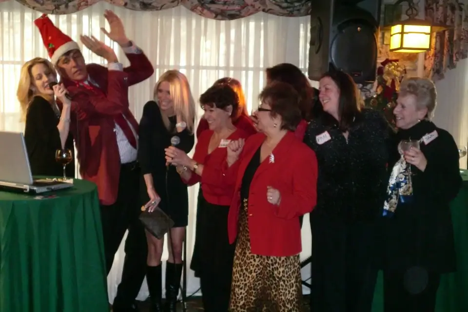 Liza and Josh singing with guests during company holiday party entertainment
