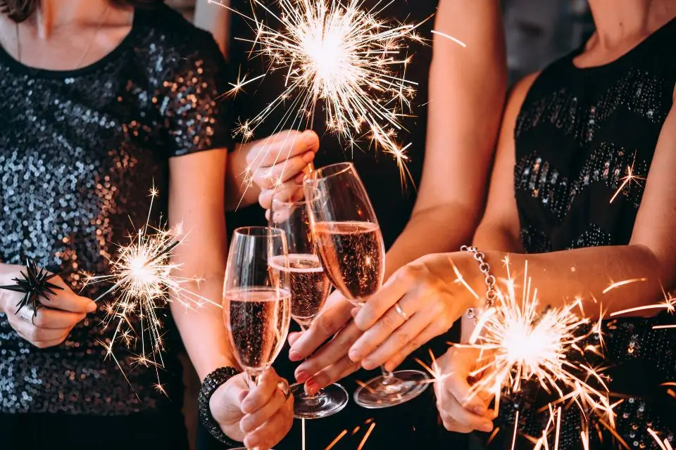 Guests celebrating with champagne and sparklers at a festive company holiday party