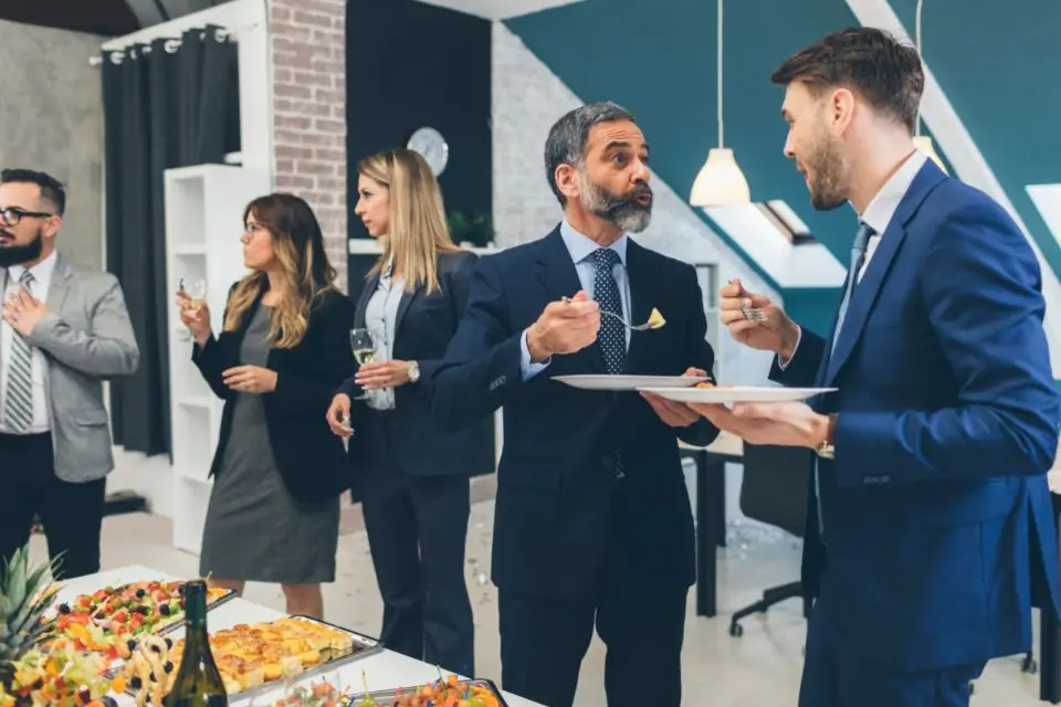 Business professionals talking over drinks and appetizers at a corporate networking event