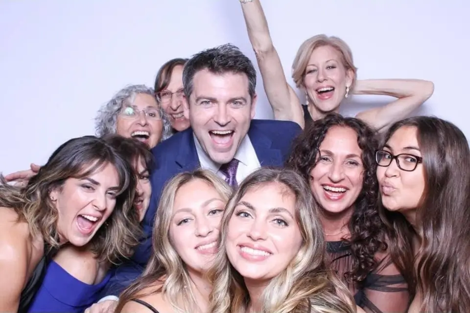 Liza and Josh having fun with guests at a corporate event photo booth in New Jersey