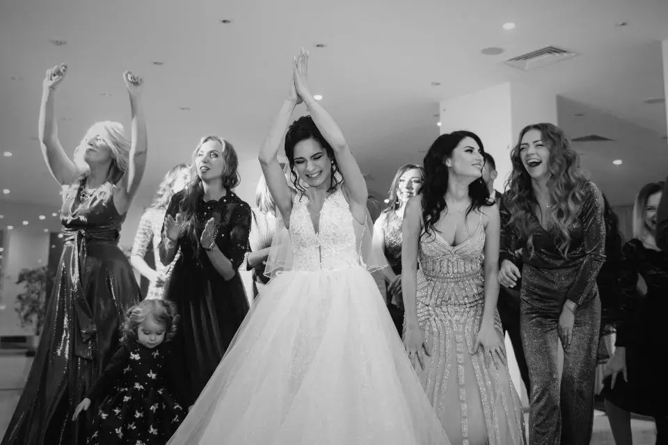 Bride celebrating and dancing with friends and family at a wedding event