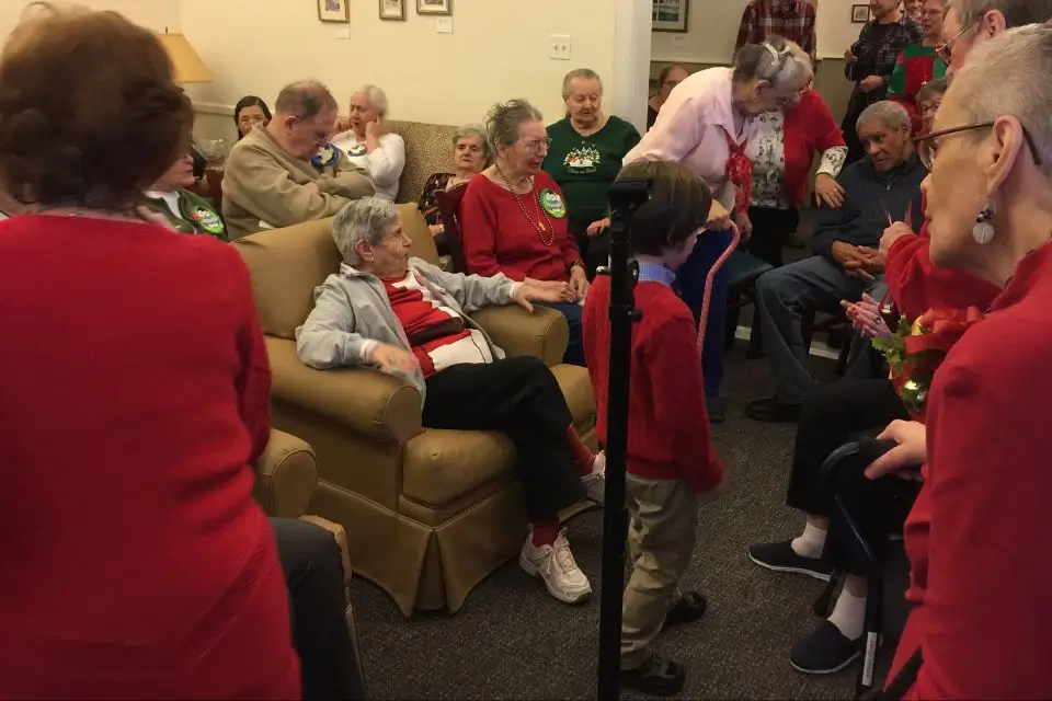 Nursing home residents enjoying holiday entertainment together in a community room