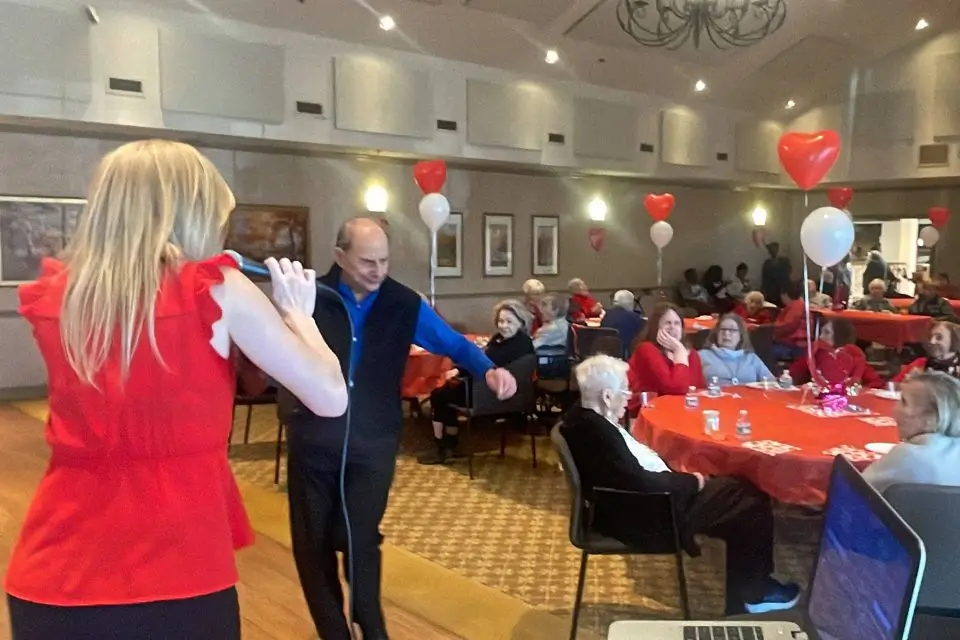Female singer performing for residents at a Valentine’s Day senior living event