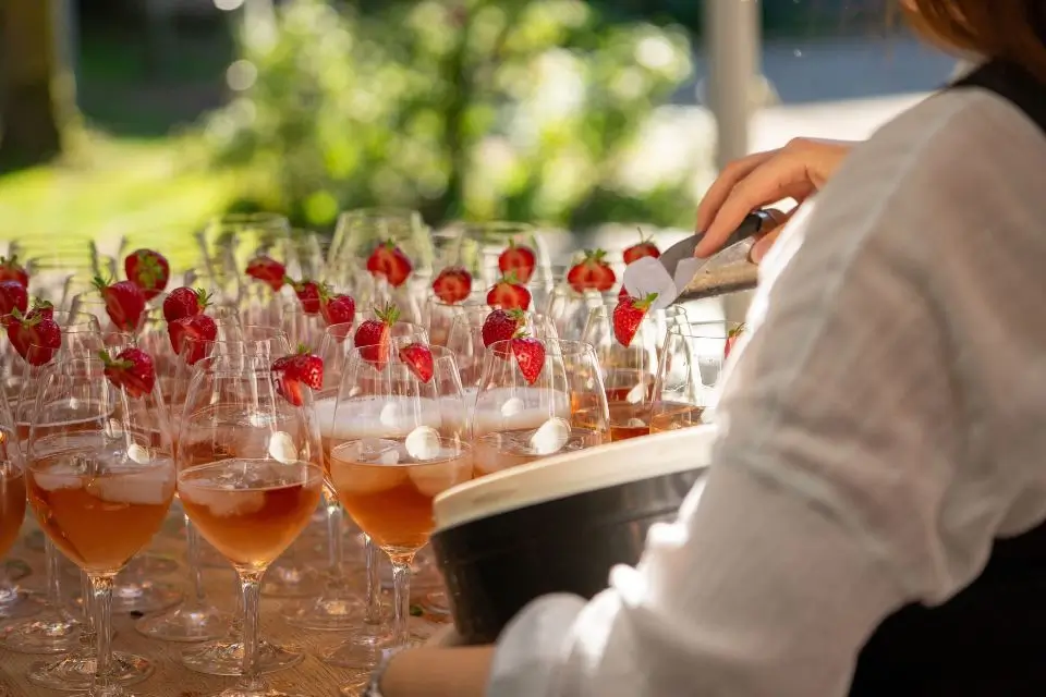 Drinks with fresh strawberries being prepared for a summer outdoor company party
