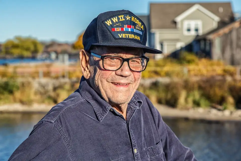 Korean War veteran smiling during outdoor music concert at a senior living community